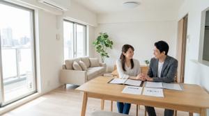 明るく開放的な2LDKマンションのリビングと売却を検討する夫婦