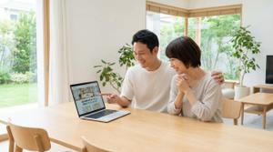 不動産売却査定の結果をPCで確認する夫婦