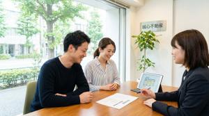 不動産売却について担当者と相談する夫婦の様子